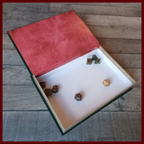 3 quarter image of an open Modular Realms Wizards Spell Book with dice in it. This packaging can not only act as a storage solution for your dungeon tiles, it can be used as a dice tray as well